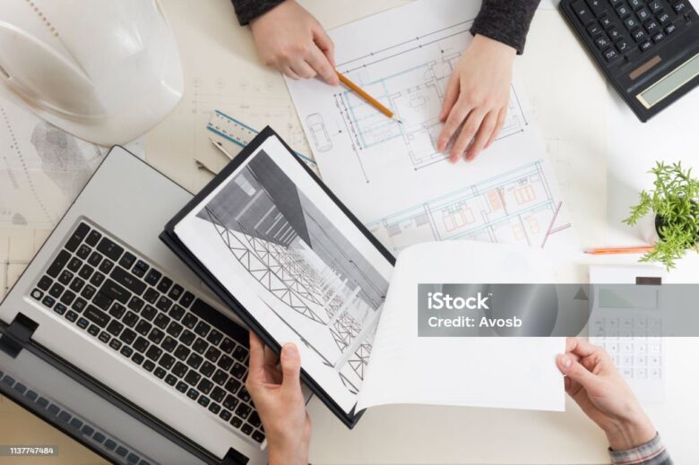 Architects working on blueprint. Architects workplace - architectural project, blueprints, ruler, calculator, laptop and divider compass. Construction concept. Engineering tools.